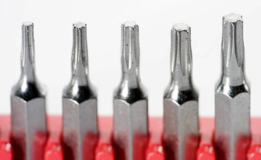 Kırmızı kutudaki alet çeliğinden yapılmış tornavida parçaları stüdyoda beyaz bir arkaplanda fotoğraflanmış.                     