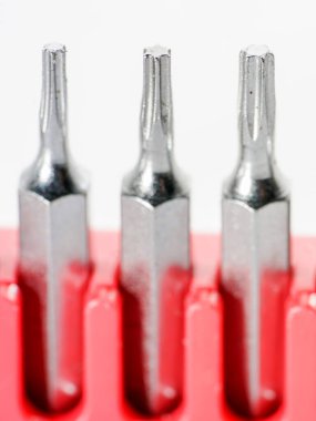 Kırmızı kutudaki alet çeliğinden yapılmış tornavida parçaları stüdyoda beyaz bir arkaplanda fotoğraflanmış.                     