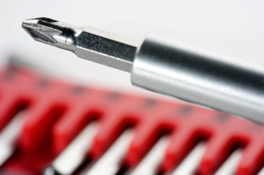 Kırmızı kutudaki alet çeliğinden yapılmış tornavida parçaları stüdyoda beyaz bir arkaplanda fotoğraflanmış.                     