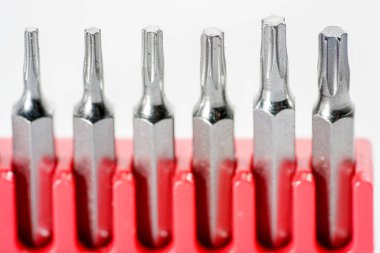 Kırmızı kutudaki alet çeliğinden yapılmış tornavida parçaları stüdyoda beyaz bir arkaplanda fotoğraflanmış.                     