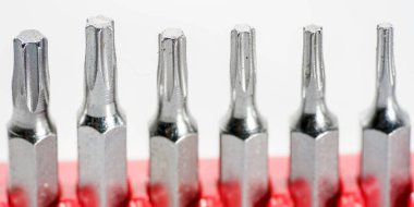 Kırmızı kutudaki alet çeliğinden yapılmış tornavida parçaları stüdyoda beyaz bir arkaplanda fotoğraflanmış.                     