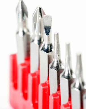 Kırmızı kutudaki alet çeliğinden yapılmış tornavida parçaları stüdyoda beyaz bir arkaplanda fotoğraflanmış.                     