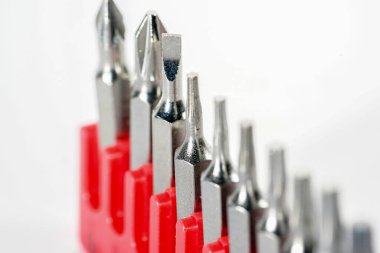 Kırmızı kutudaki alet çeliğinden yapılmış tornavida parçaları stüdyoda beyaz bir arkaplanda fotoğraflanmış.                     