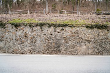 Rutubetli duvarların arasından geçen küflü taş duvar gün ışığında fotoğraflanmış.                           