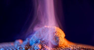 Tütsü çubuğundan tütsü tüttürürken stüdyoda renkli folyolar çekiliyor.                        