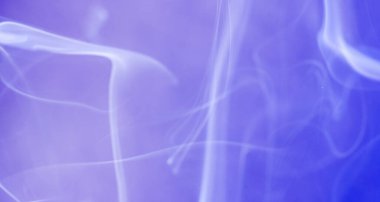 Tütsü çubuğundan tütsü tüttürürken stüdyoda renkli folyolar çekiliyor.                        