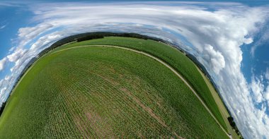 Küresel soyut panoramik hava manzarası harika bulutlar ve küçük bir gezegen gibi uzayın kıvrımlarıyla dolu bir alanda.