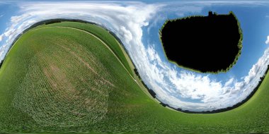 Orman ve tarladaki soyut panoramik hava manzarası. Muhteşem bulutlar ve küçük bir gezegen gibi uzayın eğriliği.                