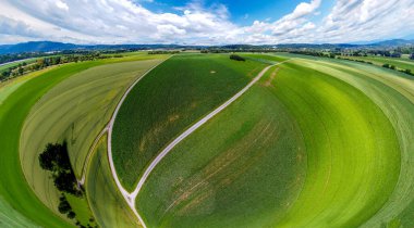 Orman ve tarladaki soyut panoramik hava manzarası. Muhteşem bulutlar ve küçük bir gezegen gibi uzayın eğriliği.                