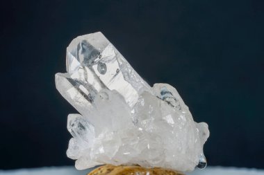 Quartz with mineral inclusions in the studio in front of black background photographed in marco mode                 clipart