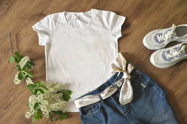 白いTシャツ 青いジーンズ 白いスニーカー 木の背景に鳥の桜の枝 モックアップ — ストック写真