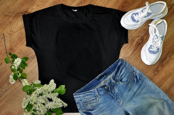 木製の背景にジーンズと白いスニーカーと黒のTシャツ モックアップ — ストック写真