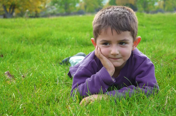 Sevimli çocuk çim üzerinde yalan — Stok fotoğraf