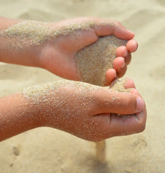 The sand flows out of the hands — Stock Photo, Image