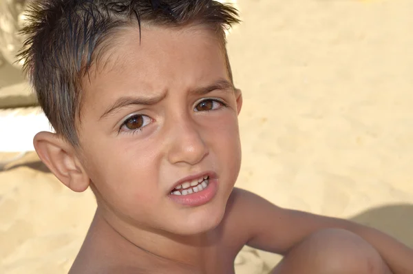 Stroppy barn vid stranden säger något — Stockfoto