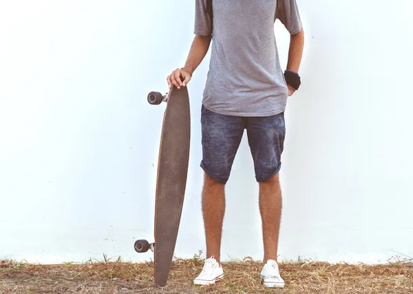 Gars sur skateboard au coucher du soleil près du mur blanc — Photo