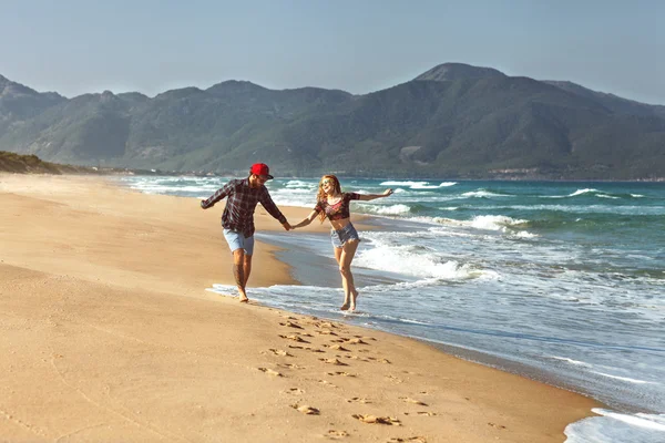 Couple amoureux marcher sur la mer jouer heureux au coucher du soleil — Photo