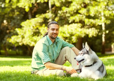 İnsan ve Husky köpeği parkta yürüyor..