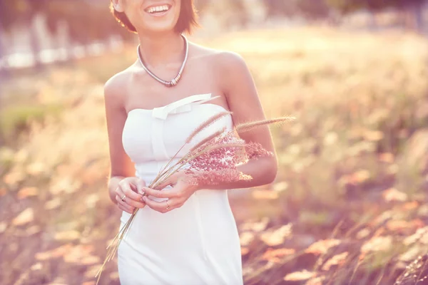 Belle fille de mode en robe blanche et avec un bouquet de sauvage — Photo