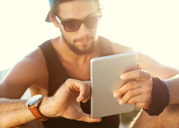 Sunny tablet in the hands of the guy on the nature — Stock Photo, Image