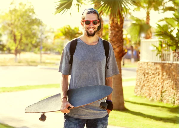 Un tipo alla hipster. Uomo di moda sul palmo della strada al tramonto — Foto Stock