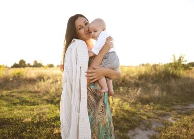 Anne ve oğlu güzel bir tarlada oynanıyor, özgürlük kavramı gün batımında.