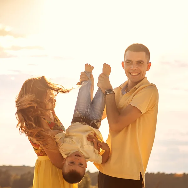 Glada vackra familjen på stranden solnedgången — Stockfoto