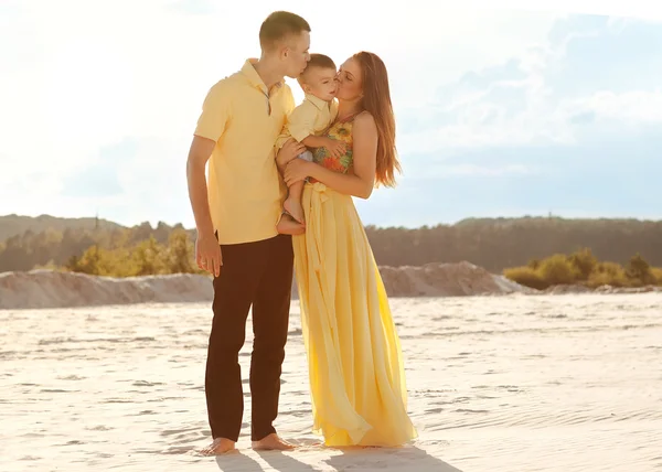 Glada vackra familjen på stranden solnedgången — Stockfoto