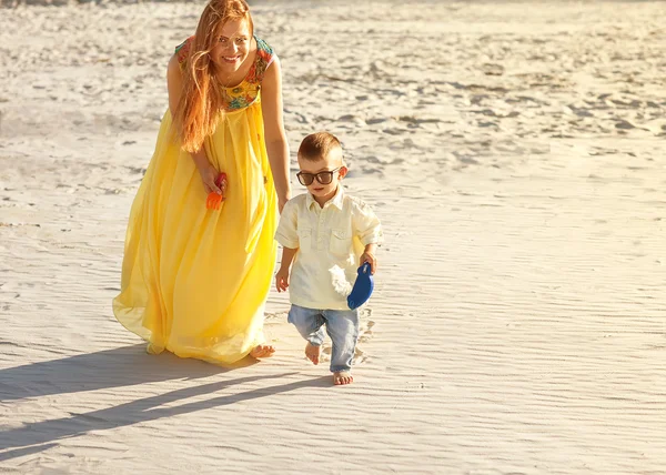 幸福的母亲和儿子在海滩日落 — 图库照片