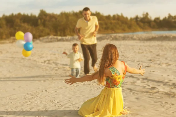 Feliz hermosa familia en la puesta de sol de la playa — Foto de Stock