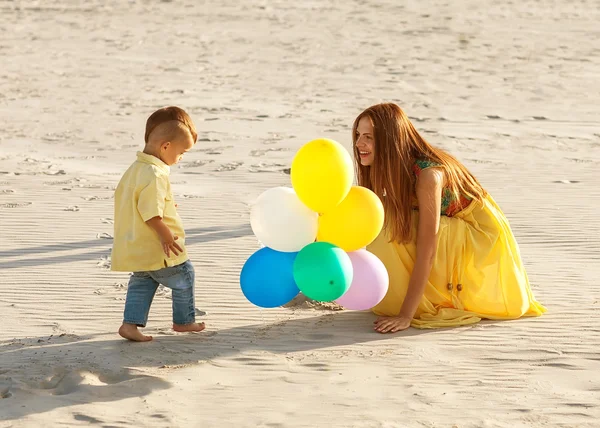 Bonne mère et son fils sur la plage coucher de soleil — Photo