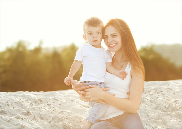 Mãe e filho felizes no pôr do sol da praia — Fotografia de Stock