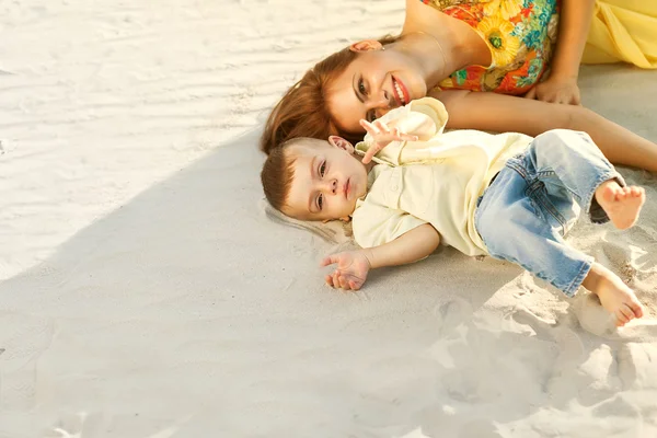 Счастливые мать и сын на пляжном закате — стоковое фото