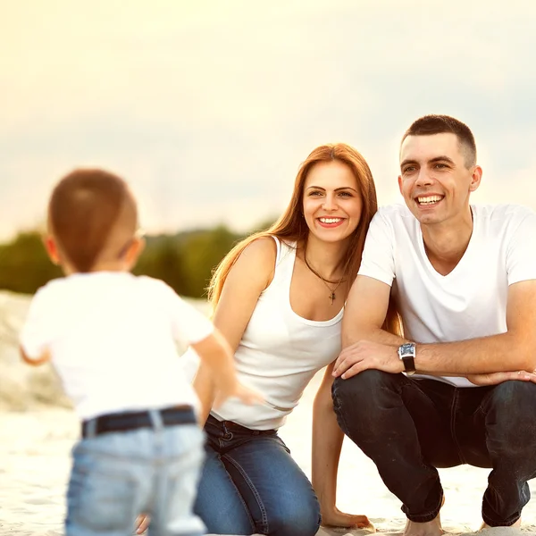 Glada vackra familjen på stranden solnedgången — Stockfoto