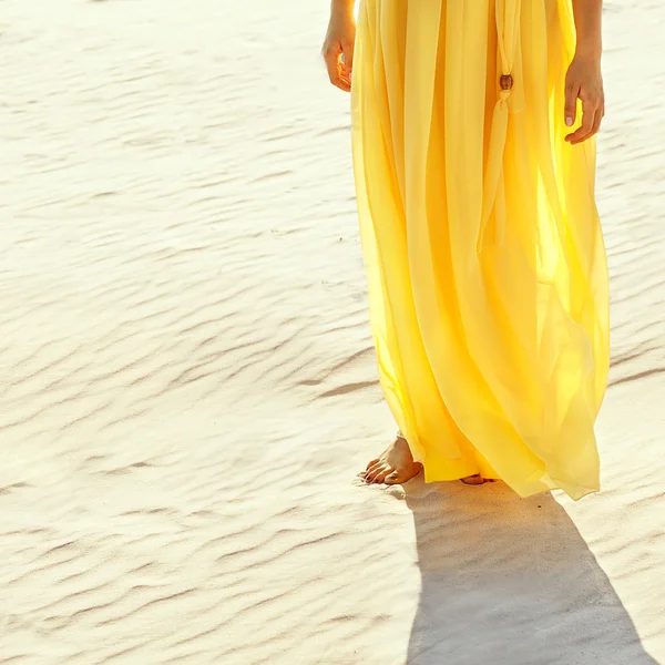 Beyaz kum üzerinde yalınayak yürümek sarı elbiseli kız — Stok fotoğraf