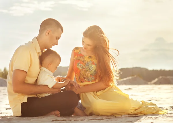 Feliz hermosa familia en la puesta de sol de la playa — Foto de Stock