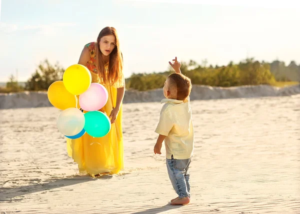 Feliz madre e hijo en la puesta de sol de la playa — Foto de Stock