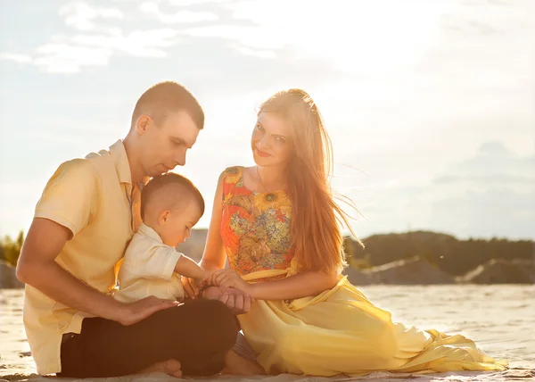 Feliz hermosa familia en la puesta de sol de la playa — Foto de Stock