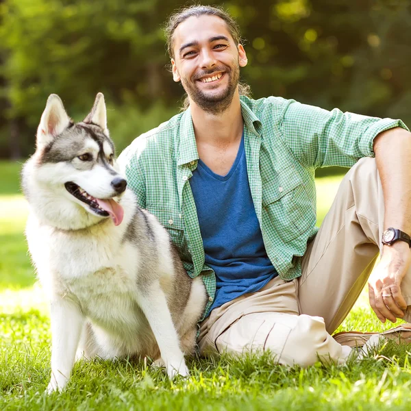 Homem e Husky cão passeio no parque . — Fotografia de Stock