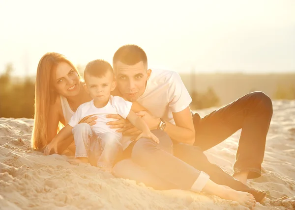 Feliz hermosa familia en la puesta de sol de la playa — Foto de Stock