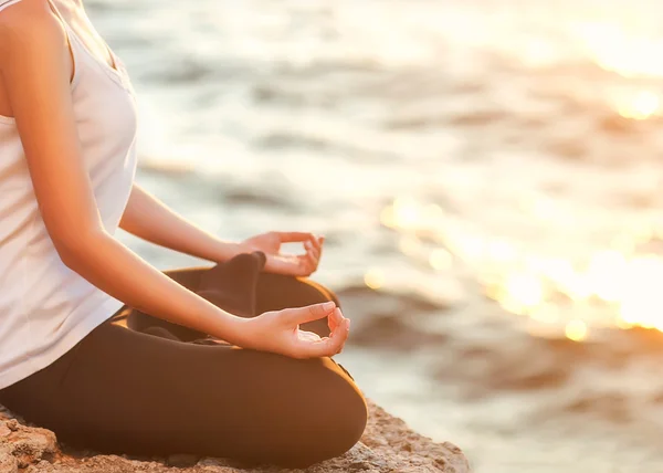 Girl in lotus pose at sunset — Stock Photo, Image