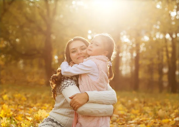 Мать и дочь веселятся в осеннем парке среди осени — стоковое фото