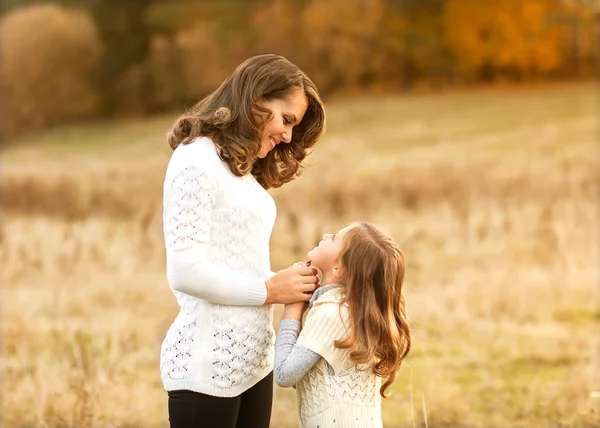 Mother and daughter walking in autumn in a field — Stock Photo, Image