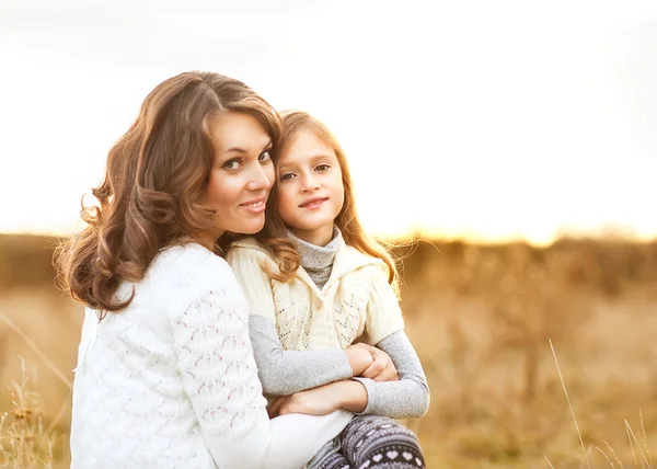 Mother and daughter walking in autumn in a field — Stock Photo, Image