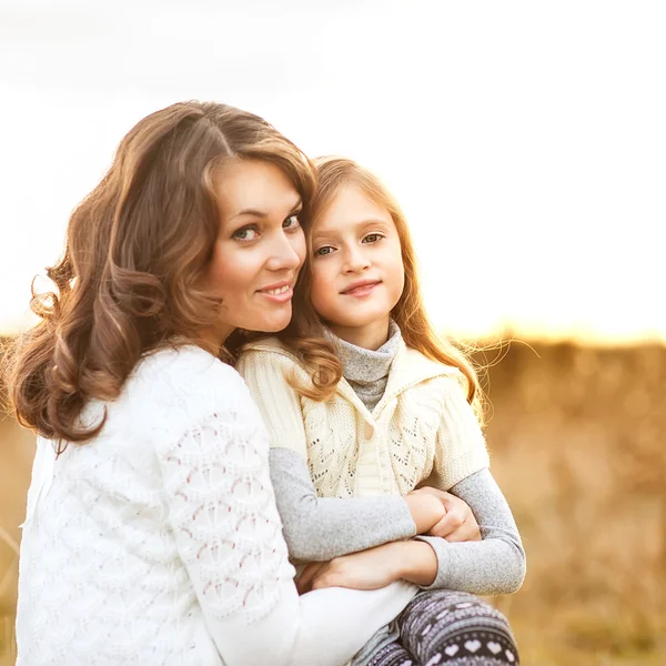 Mother and daughter walking in autumn in a field — Stock Photo, Image