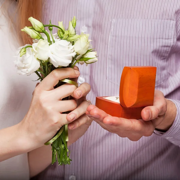 Couple de mariage tenant boîte à bague et un bouquet de fleurs — Photo