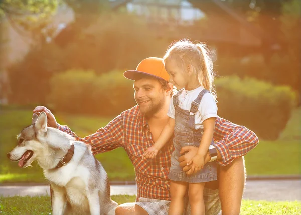 Vader en dochter spelen in het park in liefde met hond husky — Stockfoto