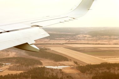 arka planda uçan uçak kanadı bulutlar,