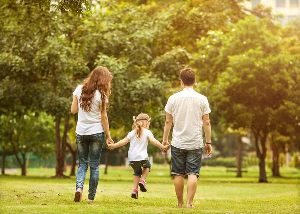 Parkta, Bangkok, Tayland için gün batımında mutlu aile yürüyüş.