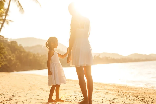 Mère et fille à la plage au coucher du soleil heureux — Photo